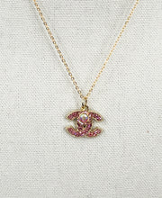 Load image into Gallery viewer, Stunning sparkle describes the Prudence Pink and Gold Vintage Coco Chanel Zipper Pull Necklace. With a gold border and spectacular pink gemstones, this brilliant style will get you noticed and give you compliments. Attached is a small pink crystal to add extra sparkle which can easily be detached if desired.