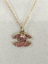 Load image into Gallery viewer, Stunning sparkle describes the Prudence Pink and Gold Vintage Coco Chanel Zipper Pull Necklace. With a gold border and spectacular pink gemstones, this brilliant style will get you noticed and give you compliments. Attached is a small pink crystal to add extra sparkle which can easily be detached if desired.