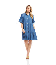 Load image into Gallery viewer, Woman wearing a blue chambray dress and sandals standing against a white background.