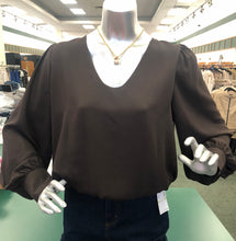 Load image into Gallery viewer, Mannequin wearing a brown blouse with a blurred store background.