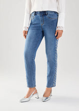 Load image into Gallery viewer, Make a statement with our Patrice Pull-On Pencil Ankle Denim, adorned with elegant pearl embellishments running down the outer side of each leg. This piece also includes a 5-pocket design and a faux zipper closure, adding a touch of contemporary style.