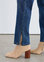 Load image into Gallery viewer, Close-up of blue jeans with gold studding details and beige boots against a neutral background.