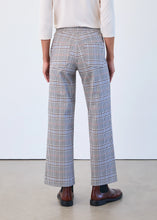 Load image into Gallery viewer, Model wearing plaid pants, white top and brown boots against a white background.