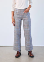 Load image into Gallery viewer, Model wearing plaid pants, white top and brown boots against a white background.