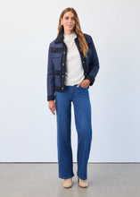 Load image into Gallery viewer, Woman wearing a blue jacket over a white lace top, wide leg blue with silver check jeans and tan suede boots against a neutral background.