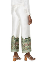 Load image into Gallery viewer, The Liverpool Los Angeles Pull-On Wide Leg Pants in Cream Olive Paisley are a stylish and comfortable addition to your wardrobe. Featuring a unique paisley print, these pants are designed with a mid-rise elastic waistband and a tie front for a secure and adjustable fit. The wide-leg cropped silhouette and slant front pockets add a touch of practicality and elegance. Crafted from lightweight woven fabric, these pants, with a satiny feel, are perfect for pairing with the matching halter top or blouse.