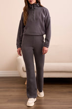 Load image into Gallery viewer, Woman wearing a gray casual zip up top, matching gray jogger and sneakers standing in a room with a beige couch.