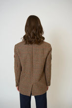 Load image into Gallery viewer, Woman wearing a plaid blazer and blue jeans against a white background.