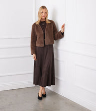 Load image into Gallery viewer, Woman wearing a brown fur coat, brown dress and black heels against a white wall.