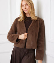 Load image into Gallery viewer, Woman wearing a brown fur coat and brown dress against a white wall.