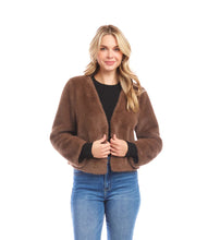 Load image into Gallery viewer, Woman wearing a brown fur jacket over a black top and blue jeans against a white background.