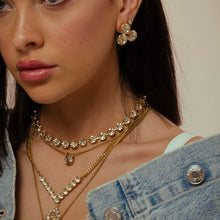 Load image into Gallery viewer, For an enduring glitter, choose the Reya Earrings from Canada! Measuring 1”, these studs with three round premium champagne crystals are crafted with brass base metal, gilded with antique gold. Furthermore, the surgical steel posts keep the earrings securely in place for lasting sparkle. Color- Gold and champagne. Diameter- I inch. Antique gold plating over brass. Premium crystals. Surgical steel posts.