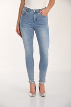 Load image into Gallery viewer, Light blue skinny jeans with embellished hem and silver heels worn by a model on a white background.