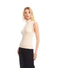Load image into Gallery viewer, Woman wearing a beige sleeveless turtleneck sweater and black pants against a white background.