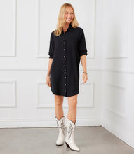 Load image into Gallery viewer, Woman wearing a black shirt dress and white cowboy boots against a white wall.