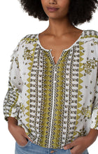 Load image into Gallery viewer, This fresh, bold and fabulous blouse has all the feminine details featuring ruffle sleeves and a beautiful batik floral print. This romantic bandana printed top is the perfect statement piece. Pairs beautifully with everything from your favorite pants to shorts. Colors -Geo floral print; black, white, greens. Lightweight gauze. Ruffle sleeve. Dolman sleeve. Pullover. Smocked waistband. Elastic at wrists.