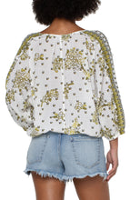 Load image into Gallery viewer, This fresh, bold and fabulous blouse has all the feminine details featuring ruffle sleeves and a beautiful batik floral print. This romantic bandana printed top is the perfect statement piece. Pairs beautifully with everything from your favorite pants to shorts. Colors -Geo floral print; black, white, greens. Lightweight gauze. Ruffle sleeve. Dolman sleeve. Pullover. Smocked waistband. Elastic at wrists.