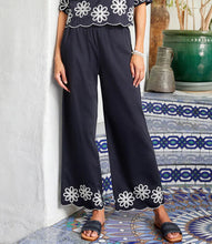 Load image into Gallery viewer, Refined yet effortlessly comfortable, the Sherrit Scallop Drawstring Pants by Karen Kane blend elegance with everyday ease. Crafted from black cotton woven fabric, these wide-leg pants feature delicate cream embroidery and a scalloped hem. Perfect for casual outings, workdays, or evening wear, these versatile embroidered pants pair beautifully with blouses, tanks, or structured tops.