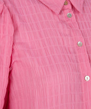 Load image into Gallery viewer, This fabulous blouse in a striking pink is made of soft seersucker quality; a light summery fabric that is slightly puckered. Our Pennie top has a collar, billowy long sleeves with a wide cuff that allows you to add extra puff to the sleeves. The top has a wider, flowy fit and looks stunning paired with white bottoms or our FALLON FLAIR JEAN IN JADE COLOR- ESQUALO. Color- Pink. Button down. Long sleeve.
