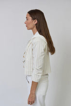 Load image into Gallery viewer, Woman wearing a white pinstripe jacket and white pants against a plain background.
