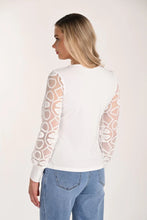 Load image into Gallery viewer, Woman wearing a white blouse with sheer sleeves and jeans against a plain background.