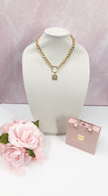 Load image into Gallery viewer, Introducing the extraordinary Shelly necklace! This piece features a rare, gold square adorned with a delicate pearl CC logo. The vintage Chanel button is elegantly suspended from a round connector, attached to a link chain. This exquisite necklace effortlessly complements any outfit. Get ready for endless compliments!