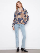 Load image into Gallery viewer, A woman modeling a long-sleeve button-up coat with a camel, navy, and white abstract floral pattern, paired with light-wash blue jeans and black ankle boots, standing against a white wall.