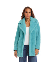 Load image into Gallery viewer, Woman wearing an aqua blue sherpa coat, white top and blue jeans against a white background.