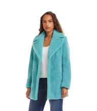 Load image into Gallery viewer, Woman wearing an aqua blue sherpa coat, white top and blue jeans against a white background.