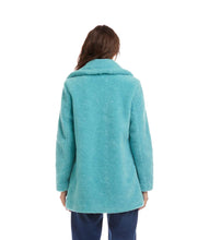 Load image into Gallery viewer, Woman wearing an aqua blue sherpa coat and blue jeans against a white background.