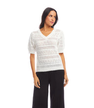 Load image into Gallery viewer, Woman wearing an off-white, short sleeve crochet top and black pants against a white background.