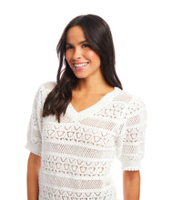 Load image into Gallery viewer, Woman wearing an off-white, short sleeve crochet top against a white background.