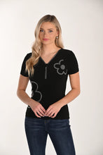 Load image into Gallery viewer, Model wearing a short sleeve black top with sequin flowers and blue jeans against a white background.