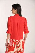 Load image into Gallery viewer, Woman wearing a red short sleeve zipper front top and floral pants on a white background.