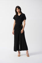 Load image into Gallery viewer, The Joseph Ribkoff Culotte Jumpsuit is a sophisticated choice for any occasion. Crafted from silky knit fabric, this jumpsuit features a chic culotte silhouette, a graceful cowl neckline, and a statement buckle ornament at the waist. With short sleeves and a back zipper for easy wear, it combines comfort and style effortlessly. Perfect for cocktail parties or elegant dinners, this jumpsuit is a versatile addition to your wardrobe.