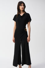 Load image into Gallery viewer, The Joseph Ribkoff Culotte Jumpsuit is a sophisticated choice for any occasion. Crafted from silky knit fabric, this jumpsuit features a chic culotte silhouette, a graceful cowl neckline, and a statement buckle ornament at the waist. With short sleeves and a back zipper for easy wear, it combines comfort and style effortlessly. Perfect for cocktail parties or elegant dinners, this jumpsuit is a versatile addition to your wardrobe.