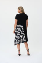 Load image into Gallery viewer, If you are looking for a comfortable and highly fashionable dress, our Soren knit woven dress is a beautiful addition to your wardrobe. A one piece, pullover dress, our Soren is a solid black on top and down one side of the dress, while the other half of its skirting is voluminous with a ruffled abstract pattern hem. This flowy dress feels as gorgeous as it looks! Color- Black and white. One piece dress. Abstract print on one side. Solid on the other. Solid color top. Ruffled hem on one side. No pockets.