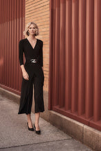 Load image into Gallery viewer, Boost your confidence in every stride with this stunning silky knit wrap jumpsuit. Designed with an overlapping culotte leg and elegant three-quarter sleeves, this garment exudes feminine grace and sophistication. Accentuate your figure with the waistline sash and sleek wrap neckline, while the delicate waist ornament adds a touch of unique charm.