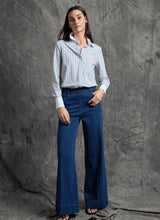 Load image into Gallery viewer, Woman wearing a striped shirt and blue trouser jean and black sandals against a gray textured background.