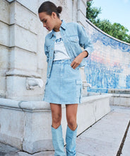 Load image into Gallery viewer, The EsQualo Distressed Jeans Skirt is a stylish denim skirt featuring a distressed design with cargo-style pockets and chic buckle details. It also has a unique button with inlaid rhinestones, adding a touch of elegance to its rugged charm. This versatile piece is perfect for casual outings or adding a trendy edge to your wardrobe.