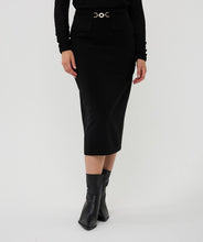 Load image into Gallery viewer, Model wearing a black long sleeve top, long black skirt with gold buckle and black boots against a white background.