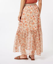 Load image into Gallery viewer, A beautiful skirt that easily transitions from the warmer to cooler months, our Taylin offers a beautiful abstract floral print in orange, brown and red against a pale peach background. Gold threading throughout and a shiny gold elastic waist band adds elegant features. The Taylin has the look of a wrap skirt but is connected for easy wear, with a ruffle running down one side of the split skirt in the front. Fully lined in beige color to the knee with a transparent look at the bottom.