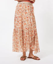 Load image into Gallery viewer, A beautiful skirt that easily transitions from the warmer to cooler months, our Taylin offers a beautiful abstract floral print in orange, brown and red against a pale peach background. Gold threading throughout and a shiny gold elastic waist band adds elegant features. The Taylin has the look of a wrap skirt but is connected for easy wear, with a ruffle running down one side of the split skirt in the front. Fully lined in beige color to the knee with a transparent look at the bottom.
