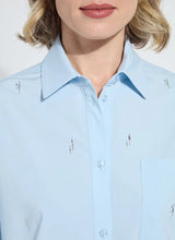 Load image into Gallery viewer, Close-up of model wearing a light blue blouse with crystal embellishments against a white background.