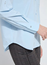 Load image into Gallery viewer, Close-up of the hem on a light blue blouse and dark plaid pants against a white background.