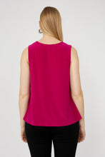Load image into Gallery viewer, Woman wearing a bright pink sleeveless top and black pants against a white background.