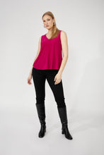 Load image into Gallery viewer, Woman wearing a bright pink sleeveless top, black pants and black boots against a white background.