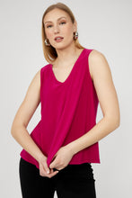 Load image into Gallery viewer, Woman wearing a bright pink sleeveless top and black pants against a white background.