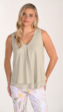 Load image into Gallery viewer, Woman wearing a pistachio green sleeveless top with floral pants on a white background.