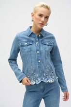 Load image into Gallery viewer, The Joseph Ribkoff Sybella Stretch Denim Jacket is a perfect fusion of classic and modern design. Made from eco-friendly Repreve® stretch denim, this piece features intricate eye-catching embroidery and sparkling rhinestones for a unique touch. With a traditional shirt collar, button closure, and functional chest pockets, it blends style and practicality. The medium blue wash makes it a versatile addition to any wardrobe, ideal for layering with both casual and dressy outfits.